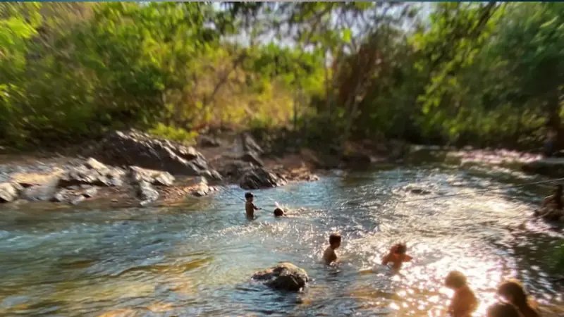 Crianças brincando no rio numa tarde de sol