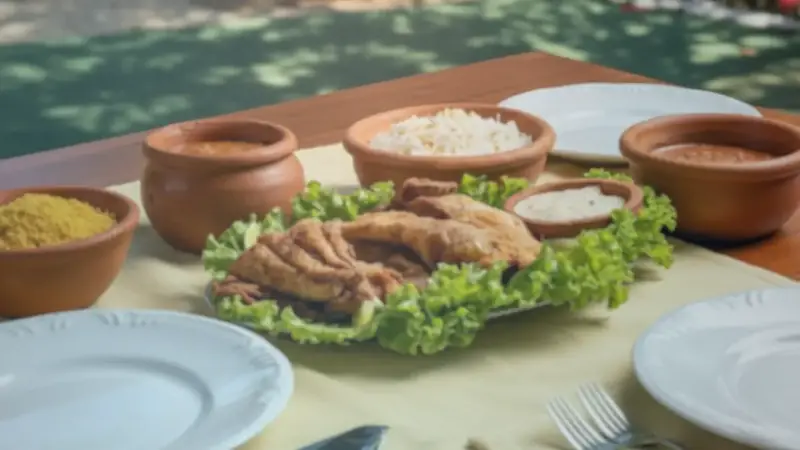 Mesa de almoço com peixe frito, arroz e farofa